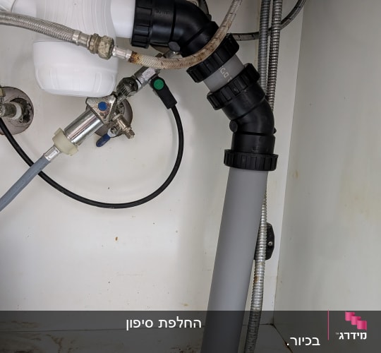 צנרת מתחת לכיור עם חיבורים וצינורות